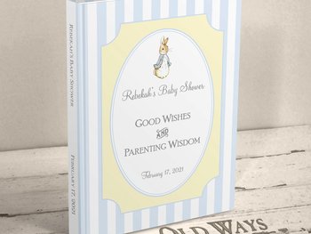 hardcover traditional baby shower guest book the cover has blue and white stripes with yellow accent in a vintage style and features an illustration of Peter Rabbit personalized with mother's name and shower date